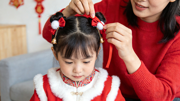 溫馨春節(jié)母親為女兒裝扮發(fā)飾新春造型兒童