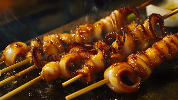 炭火炙烤铁板鱿鱼串散发诱人香气