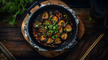 深色背景中铁板香煎茄子的诱人画面