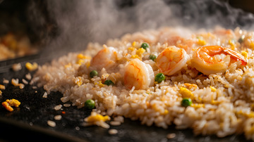 黑色铁板上的鲜虾蛋炒饭与浓郁香气散发