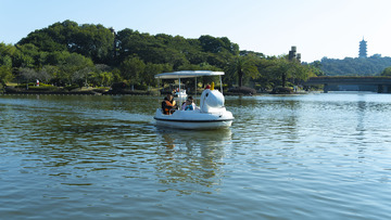 父女三人在河流中央划船