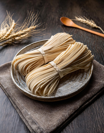 深色盘中的面条卷