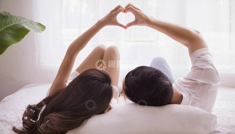 高清大图下载【趣麦麦图】一对情侣躺在床上两人的手臂高高举起共同用手比出一个心形