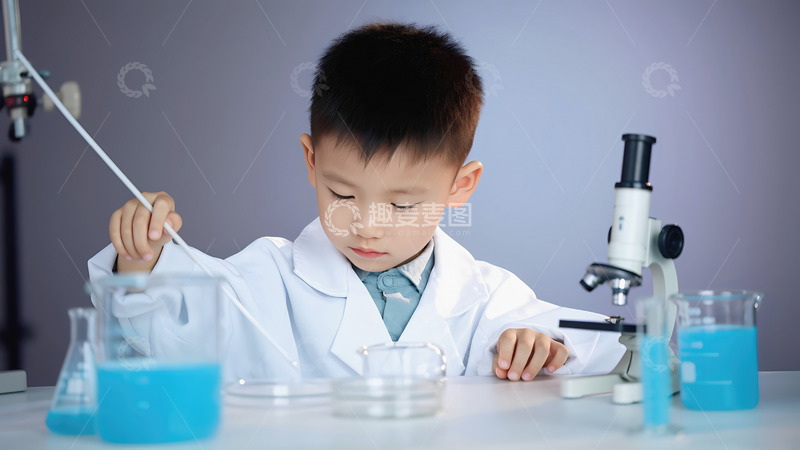 高清大图下载【趣麦麦图】一个小男孩身着白色的实验服，专注地在桌前做实验。他右手拿着一根白色的实验棒，桌上摆放着装有蓝色液体的锥形瓶