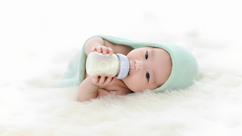 高清大图下载【趣麦麦图】一个裹着浅绿色毯子的婴儿双手捧着奶瓶1