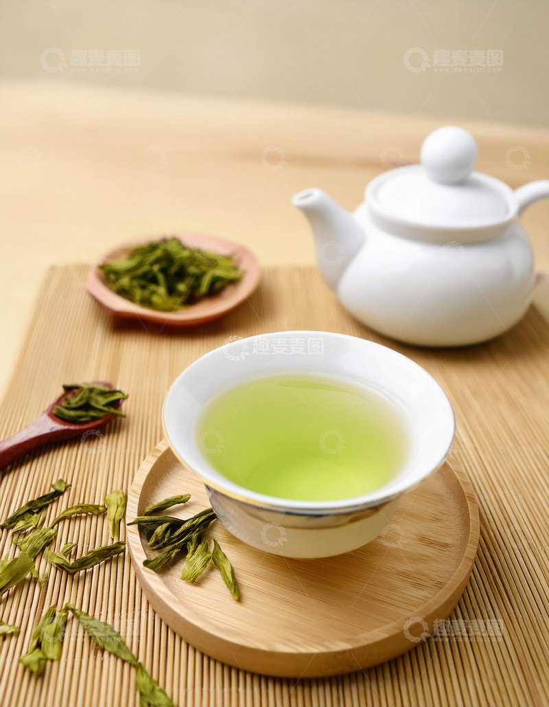 高清大图下载【趣麦麦图】-白色的茶壶，茶杯和茶托，杯中盛有泡开的绿茶，茶叶在茶汤中舒展开来，色泽嫩绿1