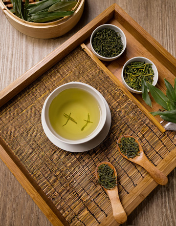 泡茶场景，画面中有白色的茶壶，茶杯，搭配木质茶盘，茶盘上摆放着茶叶，茶勺等