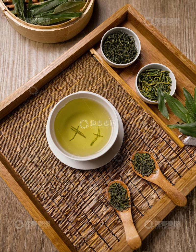 泡茶场景，画面中有白色的茶壶，茶杯，搭配木质茶盘，茶盘上摆放着茶叶，茶勺等