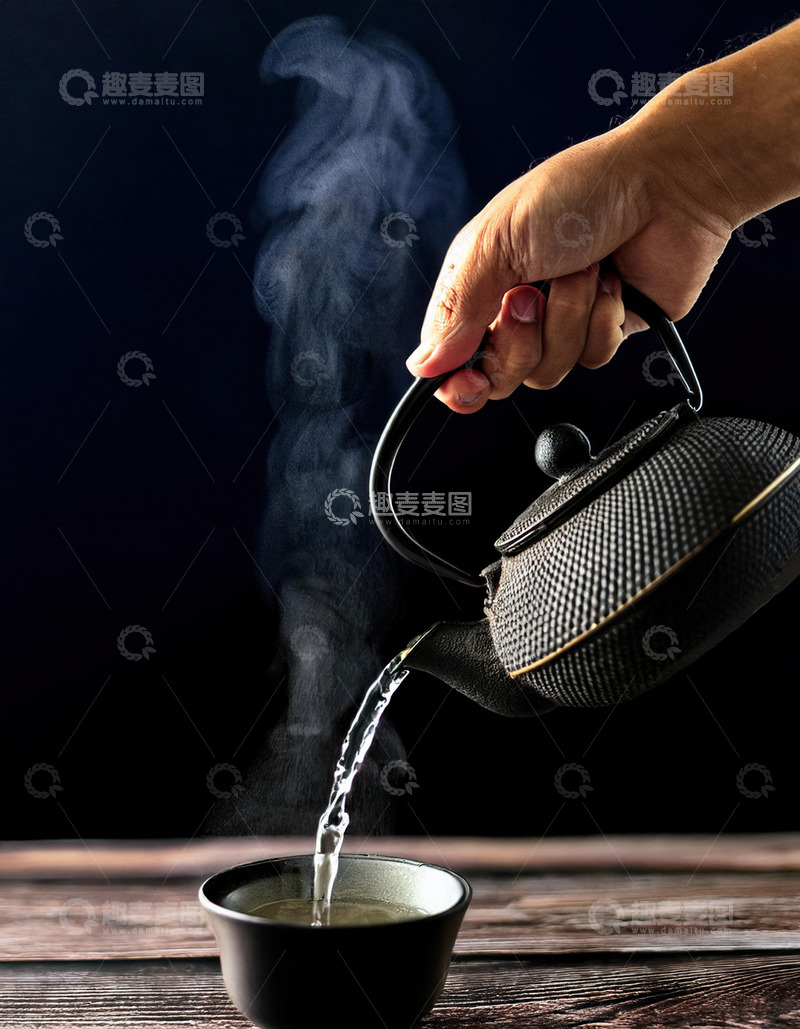 高清大图下载【趣麦麦图】一只手正握着一把黑色的铁壶，往下方的黑色茶碗中倒水，壶嘴处冒出袅袅热气，背景为深色，营造出一种古朴