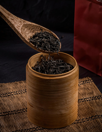 木勺舀着红茶茶叶，分别往竹制容器中倾倒1