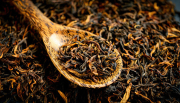 一把木勺，木勺里装满了色泽乌润的红茶茶叶