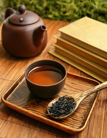 古朴的紫砂壶和茶杯放置在木制托盘上，旁边有装着红茶茶叶的木勺，营造出一种传统2