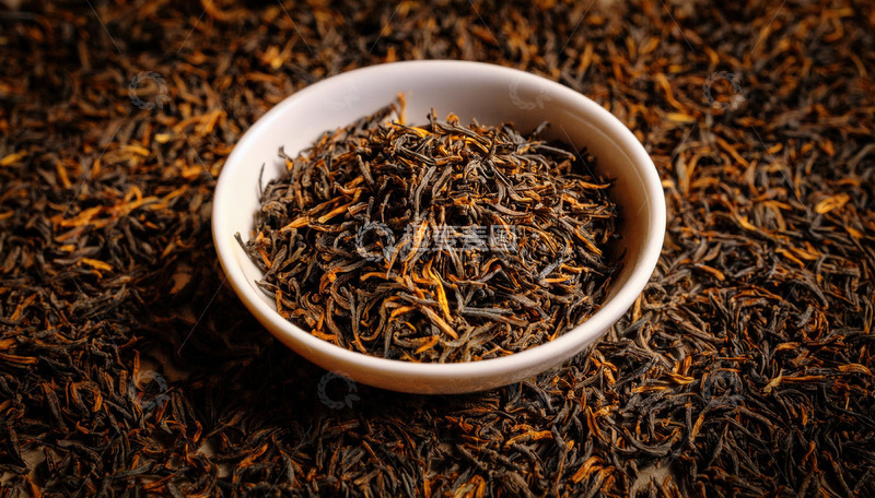 高清大图下载【趣麦麦图】白色的碗，碗中装满了色泽乌润且带有金色芽毫的红茶茶叶，背景是大量散落的同款红茶茶叶，整体突出了红茶茶叶的质感与形态1