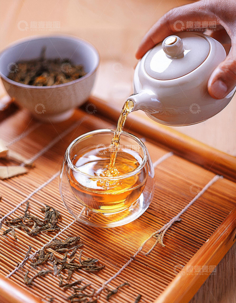 高清大图下载【趣麦麦图】，一只手正拿着白色茶壶往玻璃杯中倒红茶