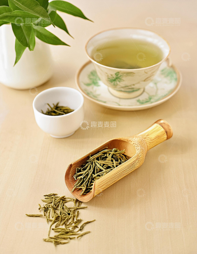 高清大图下载【趣麦麦图】一个装满绿茶的竹制茶勺放在编织垫上，茶叶自然散落，整体画面清新雅致，旁边是白色花瓶和绿植