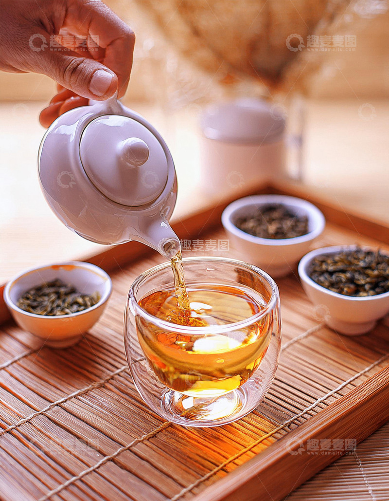 高清大图下载【趣麦麦图】，一只手正拿着白色茶壶往玻璃杯中倒红茶2