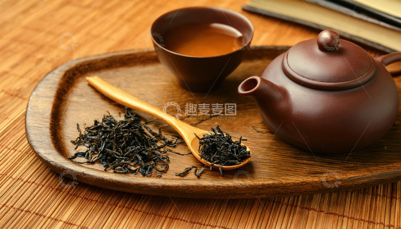 高清大图下载【趣麦麦图】-古朴的紫砂壶和茶杯放置在木制托盘上，旁边有装着红茶茶叶的木勺，营造出一种传统