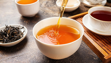 茶壶往白杯倾倒茶汤展示场景