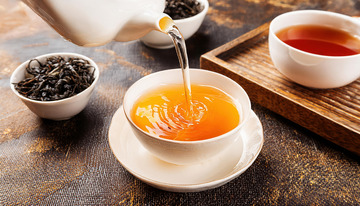 白色茶壶倾倒茶汤入白杯图1