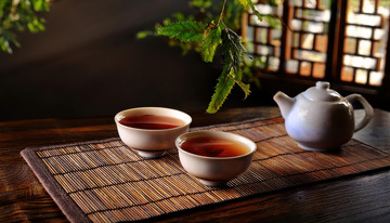 茶壶茶杯于竹席配绿植的画面1