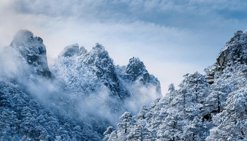 冬日里被雪覆盖的山脉景色。连绵的山峰银装素裹，云雾缭绕其间