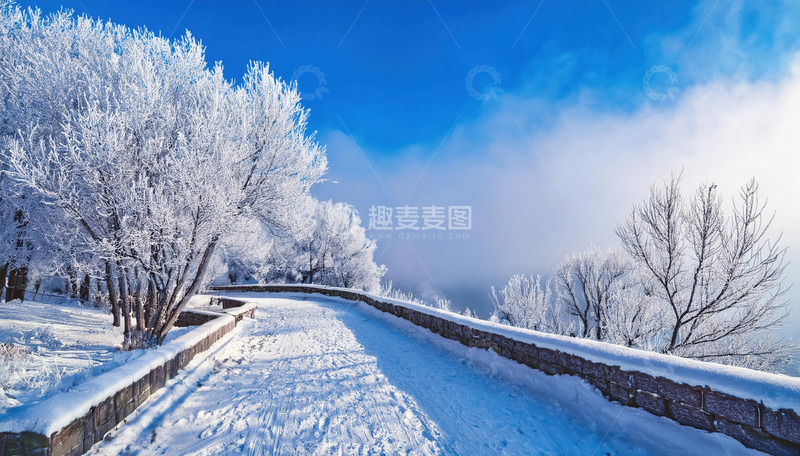 高清大图下载【趣麦麦图】冬日的雪景，一条被积雪覆盖的道路延伸向远方，道路两旁的树木挂满雾凇，洁白晶莹，还能看到木质围栏，远处云雾缭绕，蓝天映衬，展现出静谧1