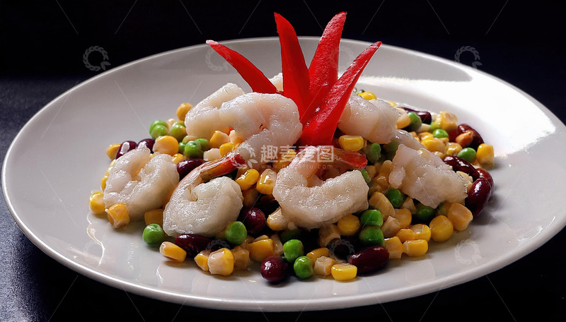 一盘装在白色盘子里的虾仁与玉米青豆等混合搭配顶部有红色装饰的菜肴