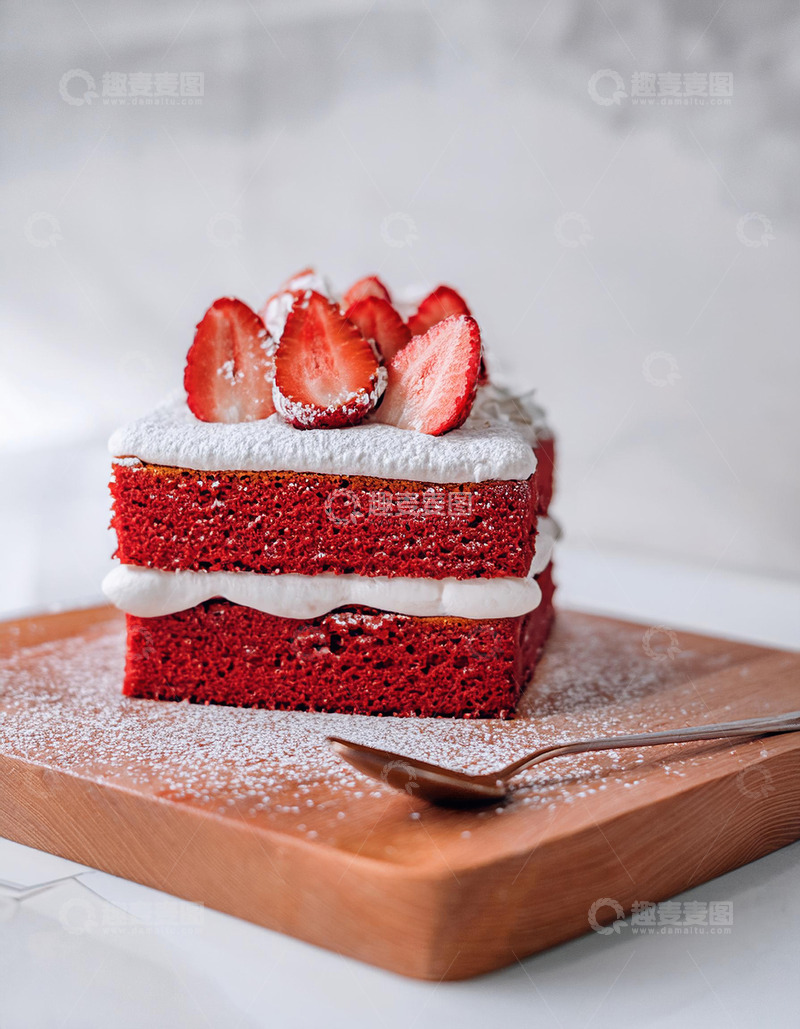 高清大图下载【趣麦麦图】-一块放在木制砧板上夹着白色奶油顶部有草莓装饰撒着糖粉的红色蛋糕旁边有银勺3