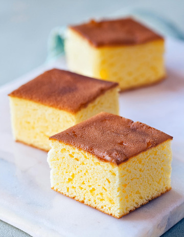 三块整齐摆放在白色盘子上的金黄色方形蛋糕1