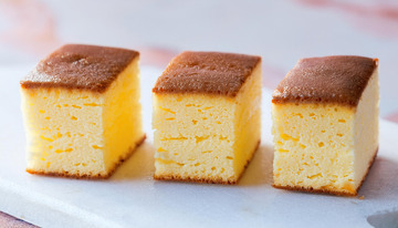 三块整齐摆放在白色盘子上的金黄色方形蛋糕2