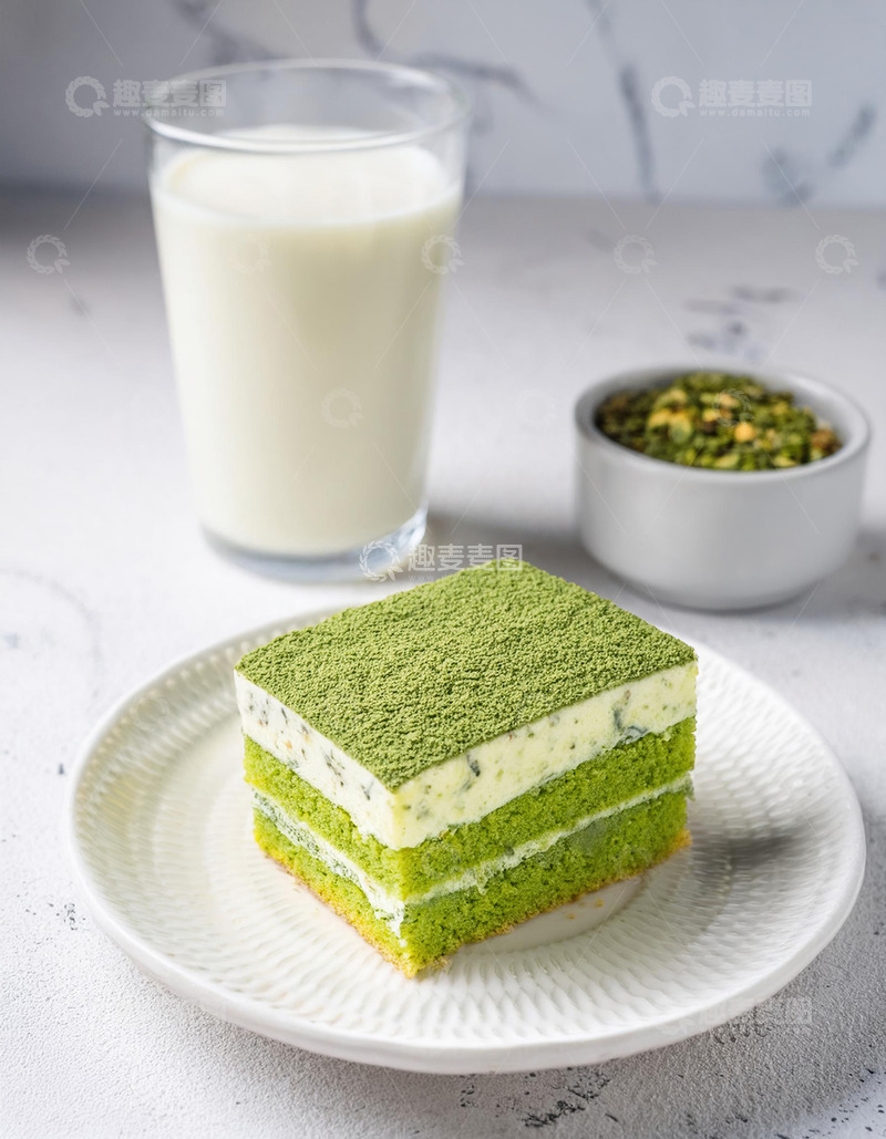 高清大图下载【趣麦麦图】一块放在白色盘子上夹着奶油和豆子的抹茶蛋糕旁边有一杯抹茶饮品2
