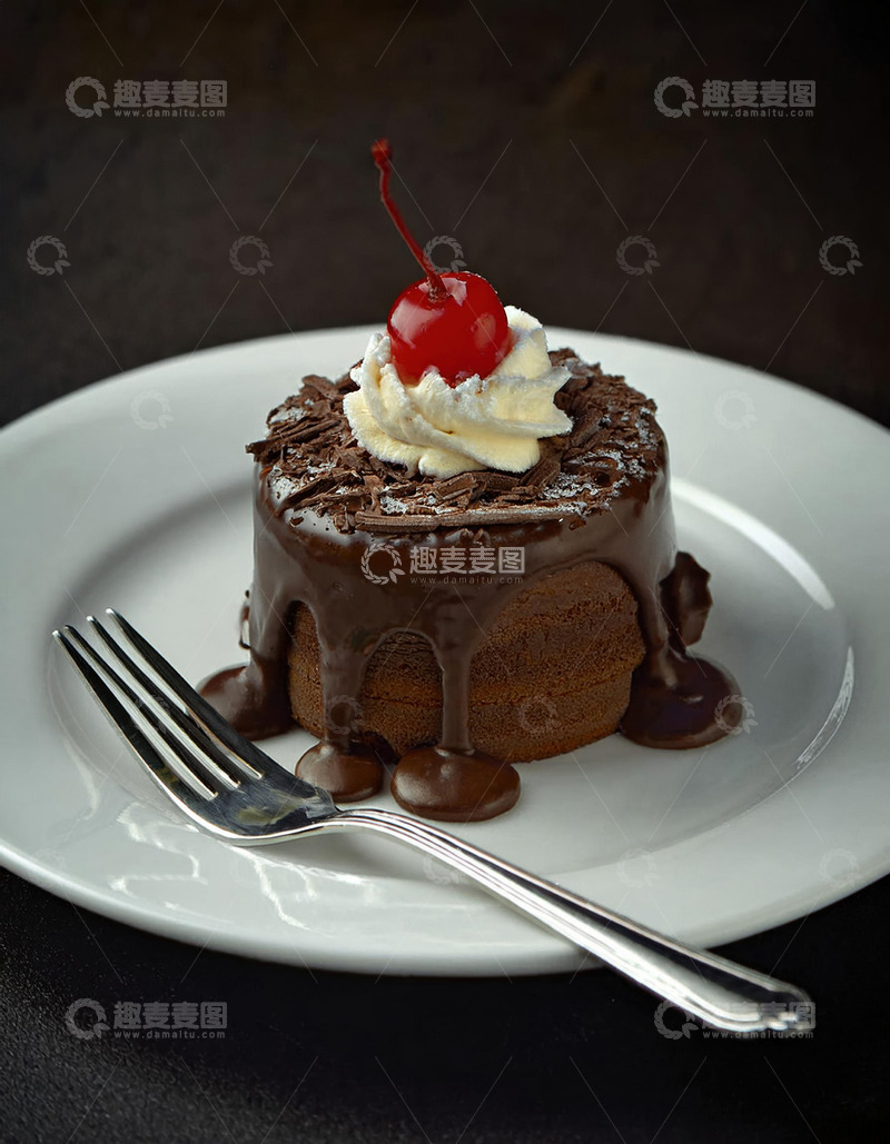 放在白色盘子上淋着巧克力酱顶部有颗樱桃和奶油的巧克力蛋糕2