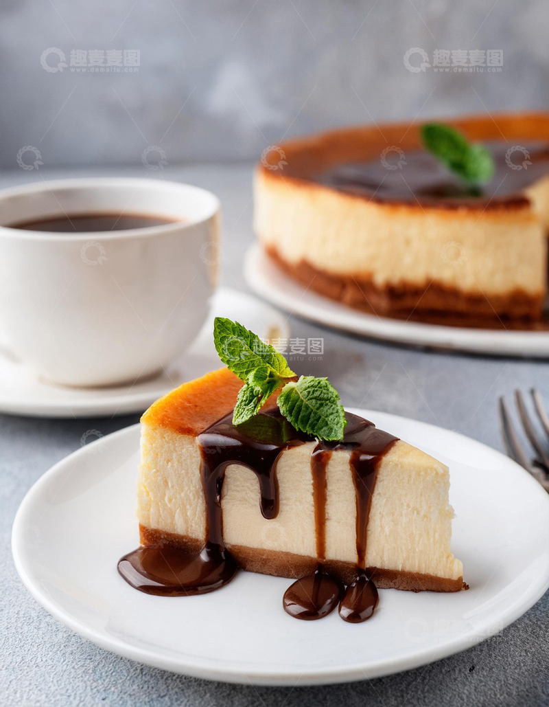 高清大图下载【趣麦麦图】一块放在白色盘子上淋着巧克力酱顶部有薄荷叶装饰的芝士蛋糕旁边有一杯咖啡3