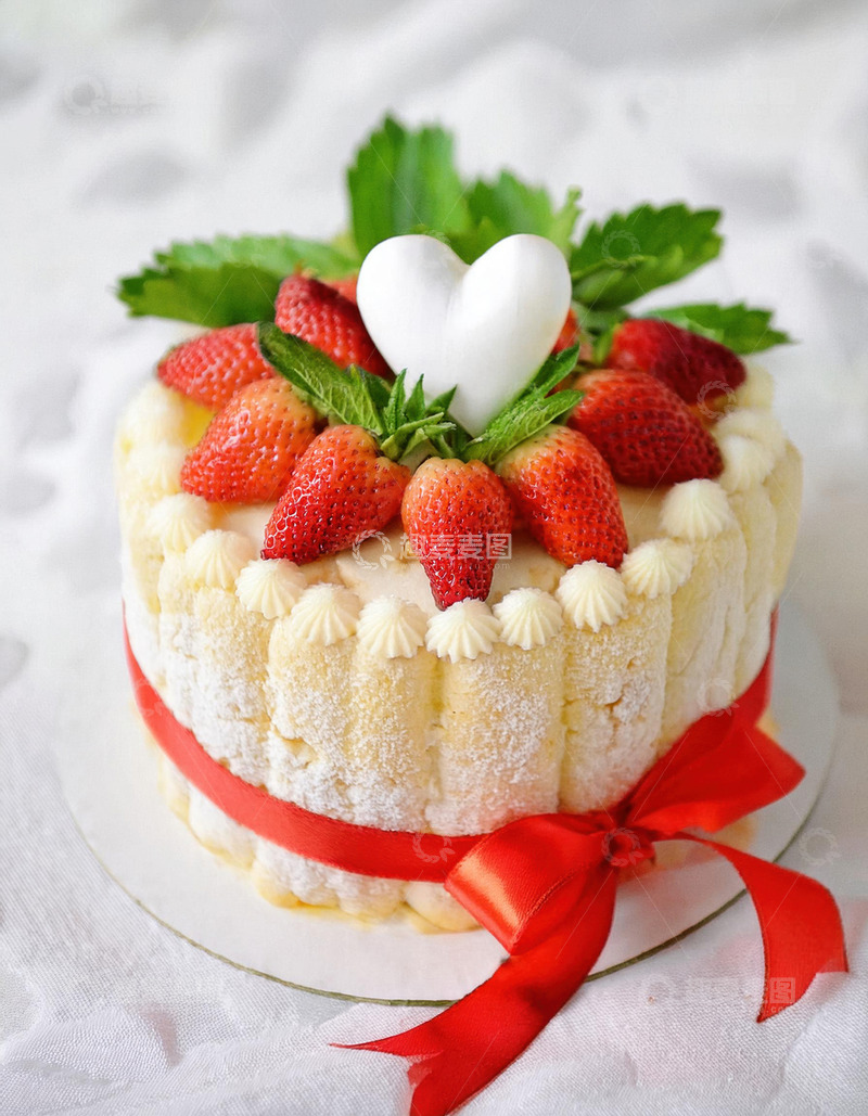 高清大图下载【趣麦麦图】一个放在金色底盘上装饰着草莓绿叶和白色心形物系着红丝带的蛋糕1