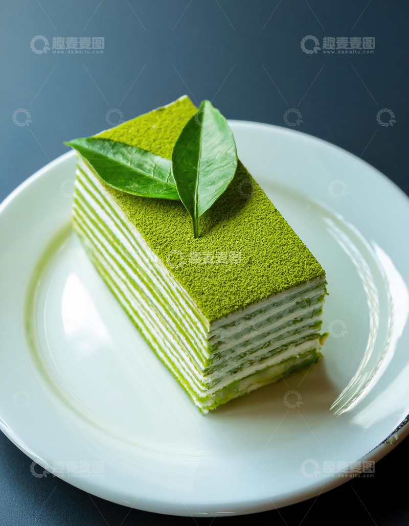 高清大图下载【趣麦麦图】-一块放在白色盘子上夹着白色奶油顶部有绿叶装饰的抹茶千层蛋糕3