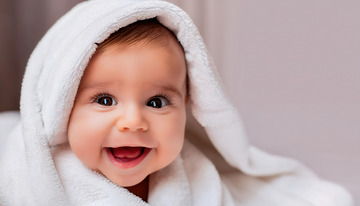 裹着白色毛巾露出开心笑容的婴儿1