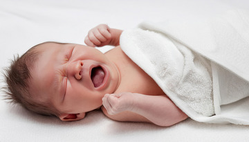 白色襁褓的婴儿展现出哀伤哭泣表情