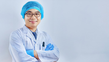 白色医护服头戴蓝色帽子戴着眼镜双臂交叉面带微笑的医生2