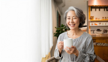 老奶奶在室内手持白色杯子面带笑容展现愉悦的图片