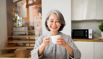 老奶奶在室内手持白色杯子面带笑容展现愉悦的图片1