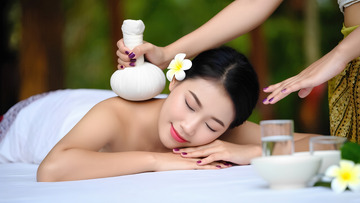 女士享受特色泰式草药球按摩