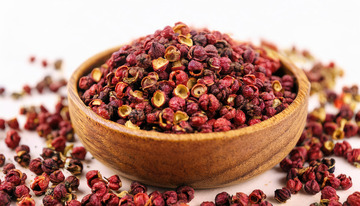 木碗盛花椒，颗粒散落于旁