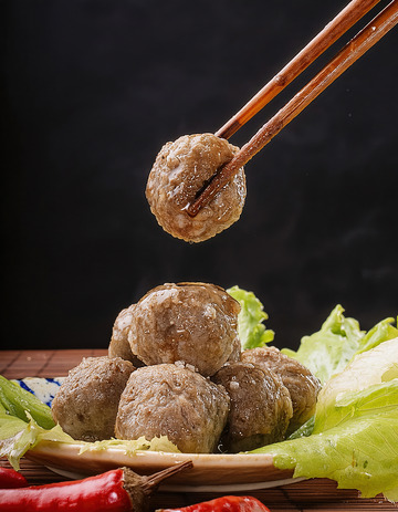 筷子夹牛肉丸，生菜红椒衬美味