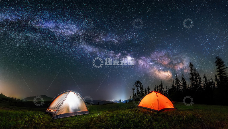 星空下草地旁的两顶露营帐篷