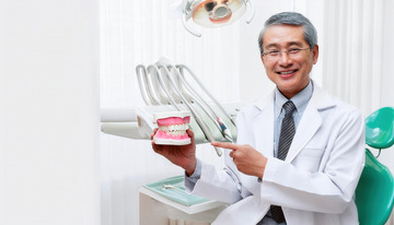 牙医手持牙齿模型耐心讲解