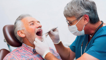 牙医为老人认真做口腔检查