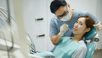 男牙医为女患者专注检查牙齿