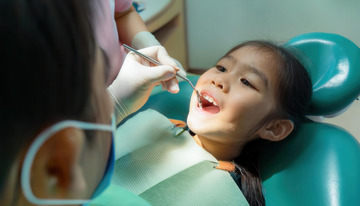 小女孩在牙科椅上接受牙齿检查