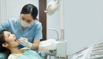 女牙医为患者细心进行口腔检查