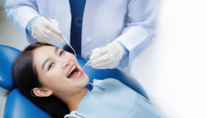 高清大图下载【趣麦麦图】牙医为年轻女士专注检查牙齿